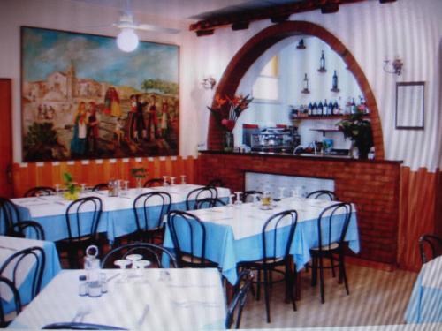 贾迪尼-纳克索斯Hotel La Rusticana的一间带桌椅和壁炉的用餐室