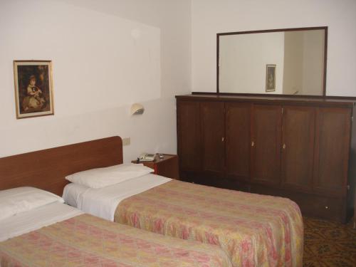 贾迪尼-纳克索斯Hotel La Rusticana的酒店客房,设有两张床和镜子