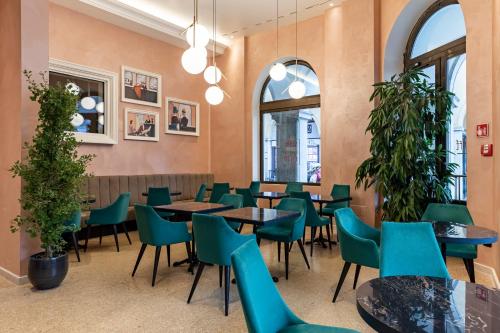 博尔扎诺斯塔德特希塔酒店的用餐室配有桌椅和植物