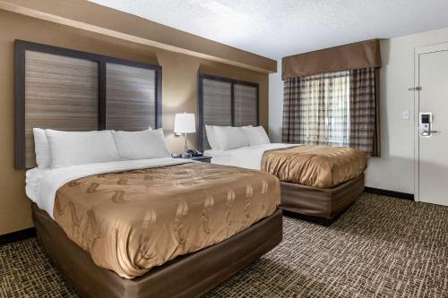 斯普林莱克Quality Inn & Suites Spring Lake - Fayetteville Near Fort Liberty的酒店客房带两张床和两个窗户