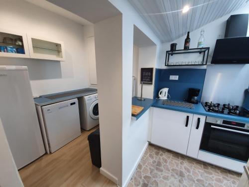 埃塔普勒RACINES MARINES的厨房配有白色橱柜、洗衣机和烘干机