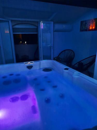 Saint-Mitre-les-RempartsMaison avec jacuzzi的紫色灯房内的浴缸