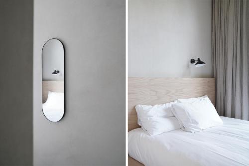 鹿特丹Hotel âme的卧室在床边墙上设有镜子