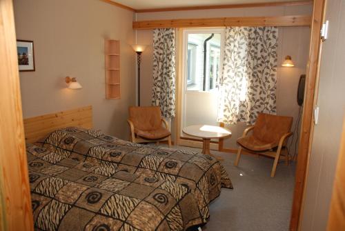 Ljosland洛斯兰德山顶别墅酒店的卧室配有一张床和一张桌子及椅子