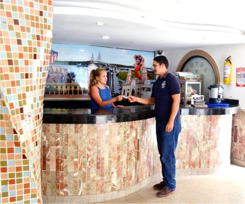 巴兰基亚hotel interamericano的站在酒吧的男人和女人