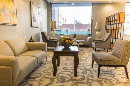 利雅德Golden Garden Hotel Suites的大堂配有沙发、椅子和桌子