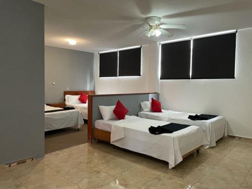 阿瓜斯卡连特斯HOTEL SiCILIA iTALIA的一间卧室配有两张床和吊扇