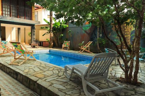 帕拉蒂Hostel Morada do sol Paraty的一个带椅子和桌子的游泳池