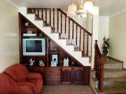 卡马拉-德洛布什Casa do Terço的客厅设有楼梯、电视和椅子