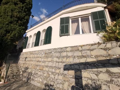 拉帕洛Rapallo Summer House的石墙上带有绿色百叶窗的建筑