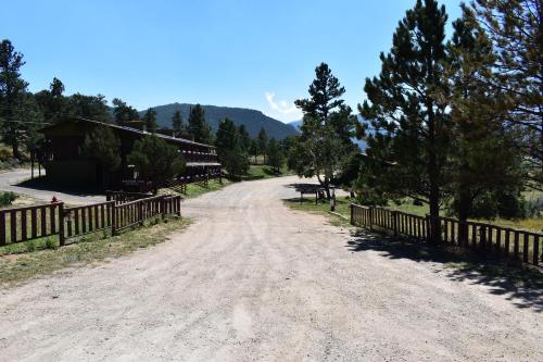 埃斯蒂斯帕克Estes Lake Lodge的一条土路,靠近栅栏和树木