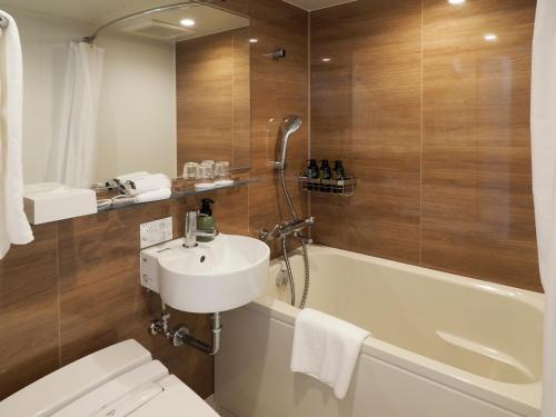 横滨横滨远东乡村酒店(Far East Village Hotel Yokohama)的浴室配有卫生间、盥洗盆和浴缸。