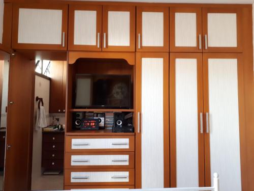 里约热内卢Hosts in Rio Homestay的一间带电视和木柜的客厅