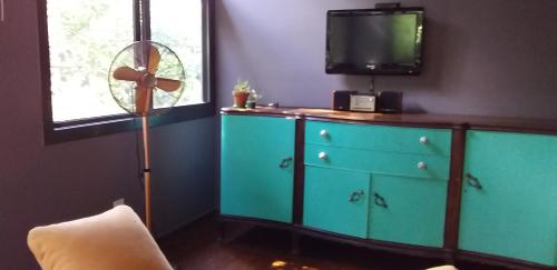 坦季Torito's House 1的一间房间,配有一个蓝色梳妆台,里面配有电视