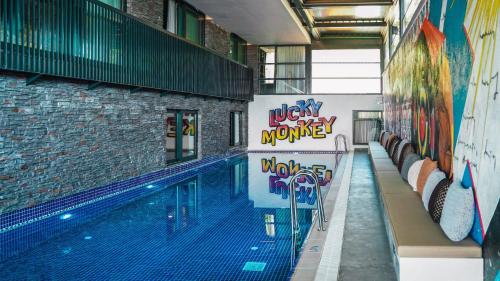 安塔利亚Lucky Monkey Hotel的一座建筑物边的游泳池,上面有涂鸦