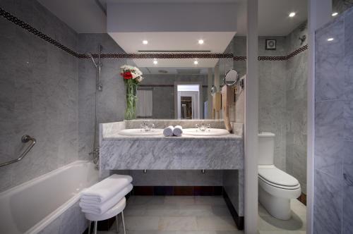 贝纳卡松Hotel Abades Benacazon的一间带水槽、浴缸和卫生间的浴室