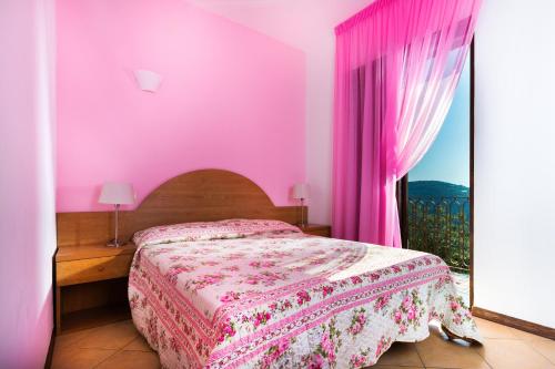 维克艾库塞 橄榄树度假酒店的粉红色的卧室设有床和窗户