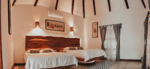 蒙特里科Dos Mundos Pacific Resort的白色墙壁客房的两张床