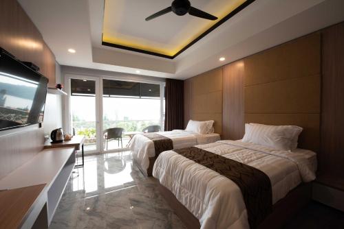 贝都古Dedanau Hotel的酒店客房设有两张床和一台平面电视。
