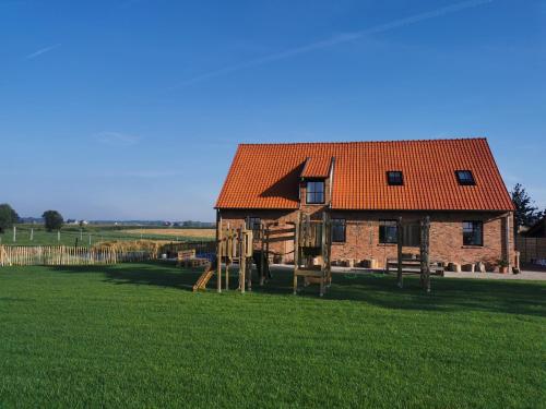 波佩林赫Sint-Sixtus 99的一座带橙色屋顶和游乐场的房子