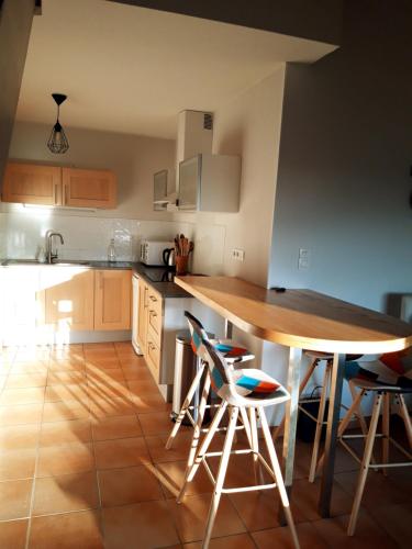 苏斯通T3 duplex lumineux en centre-ville (plage à 10mn)的厨房配有木桌和椅子