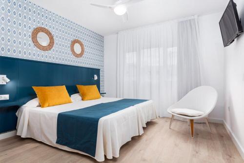 科蒂略Cotillo House的蓝色和白色的卧室,配有床和椅子