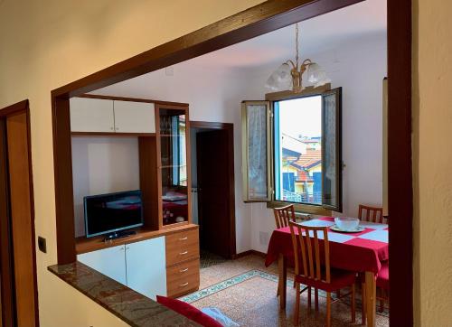 圣雷莫Casa Dei Nonni的厨房以及带桌子和电视的用餐室。