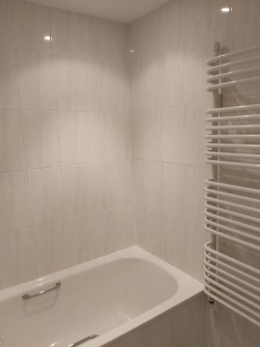萨克斯曼德姆Chauffeur's, Snape的白色的浴室设有浴缸和白色瓷砖墙。