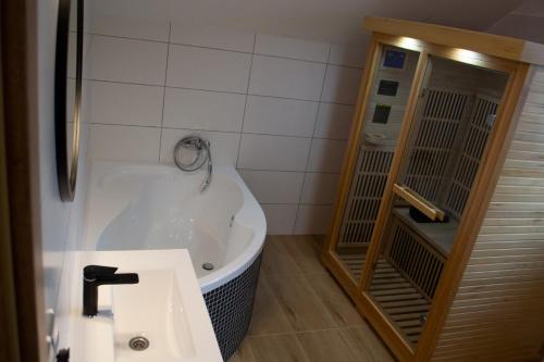 特罗亚诺维采Chata u Potůčku的带浴缸和盥洗盆的浴室