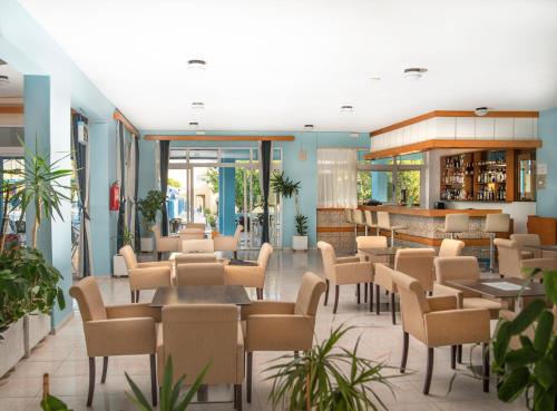 蒂加基蒂加基绿洲酒店的大堂内的餐厅,配有桌椅