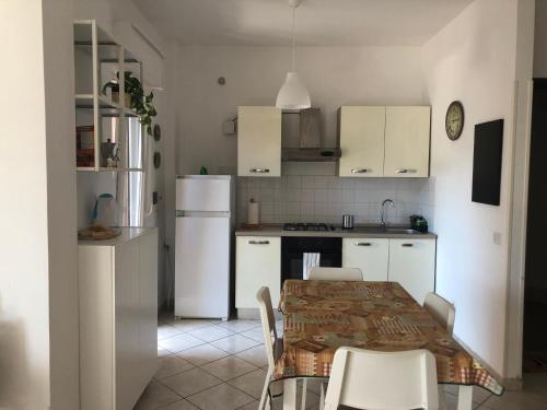 圣塔马利奈拉La Casa del Sole的厨房配有白色家电和桌椅