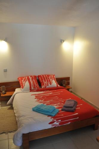 ChantesseLa Bourgeat的一间卧室配有红色和白色床单