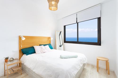 巴哈马尔Home2Book Charming Apartment Bajamar的白色卧室设有一张大床和窗户