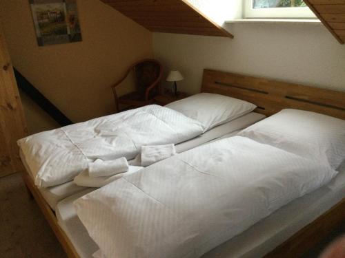 迈宁根Ferienhaus und Privatvermietung Andrea Giesecke的卧室内的两张床,配有白色床单和枕头
