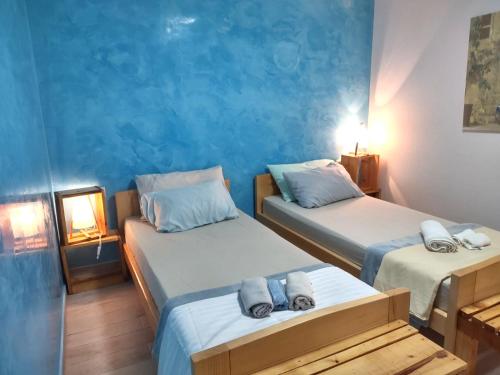 耶尔萨Stone Villa Hvar Ana and Nikola Beachfront的蓝色墙壁客房的两张床