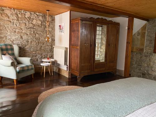 RíosecoEl Apartamentin - en el corazón del Parque Natural de Redes的一间卧室配有一张床、一个橱柜和一把椅子