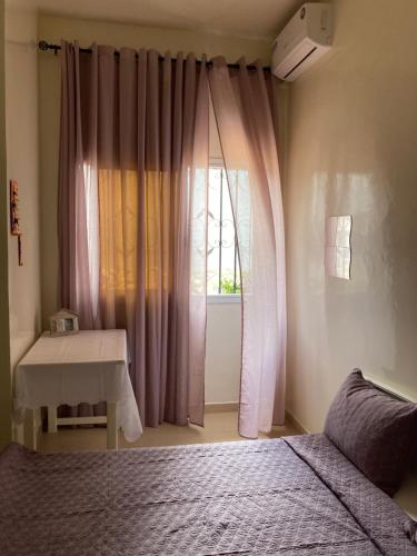 DiokoulChez Camille a Zac Mbao的一间卧室配有一张床,窗户配有桌子