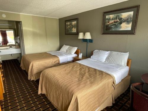 约翰逊城Bravo Inn的酒店客房设有两张床和窗户。