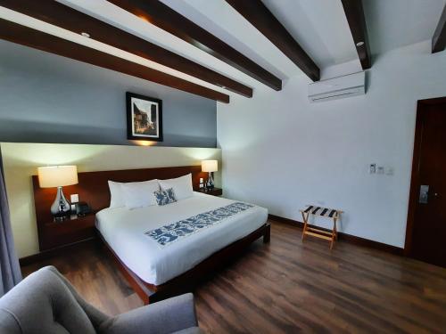 萨卡特兰Casa San Miguel Hotel Boutique y Spa的一间卧室配有一张大床和一张沙发