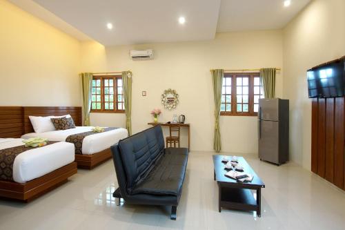 日惹S5 Guest House Yogyakarta的一间卧室配有两张床、一张沙发和一张桌子