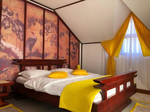 锡吉什瓦拉Casa Lily - Japanese Retreat的一间卧室配有一张带黄色枕头的大床