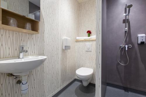 朗戈涅hotel le beauséjour的浴室配有卫生间、盥洗盆和淋浴。
