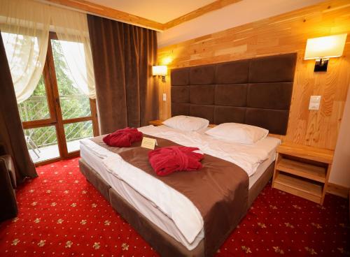 亚列姆切罗曼蒂克SPA酒店 的一间卧室配有一张大床和红色枕头