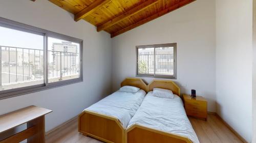 拿撒勒Cozy wood apartment with great view to Nazareth的一间小卧室,配有床和2个窗户