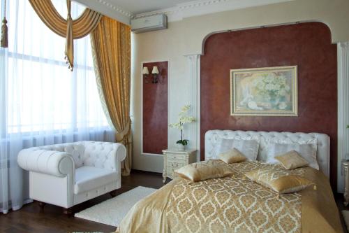 赫梅利尼茨基所博科夫酒店的卧室配有白色的床和白色椅子