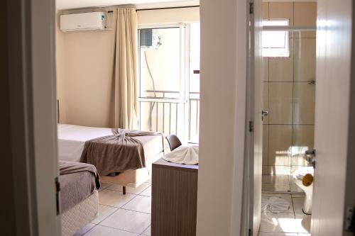 瓜拉普阿瓦Royal Trip Hotel的一间带一张床和淋浴的小卧室