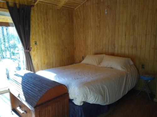 比亚里卡Cabaña entre Arboles的卧室配有木墙内的一张床