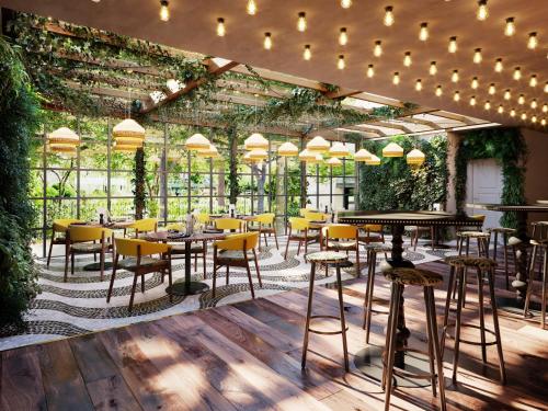 沃尔堡Holiday Inn The Hague - Voorburg, an IHG Hotel的一间设有桌椅的餐厅,种植了植物