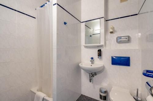 柏林A&O柏林克鲁姆布斯酒店 的白色的浴室设有水槽和卫生间。