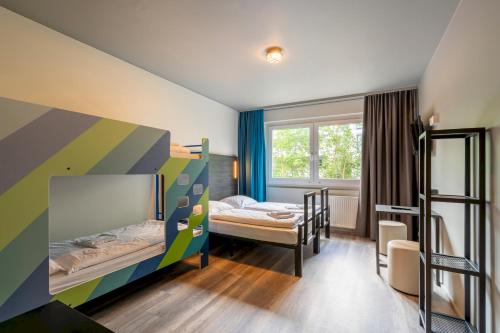 柏林A&O柏林克鲁姆布斯酒店 的客房设有两张双层床和一扇窗户。
